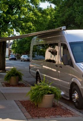 Large silver van with blackened windows and an extended awning