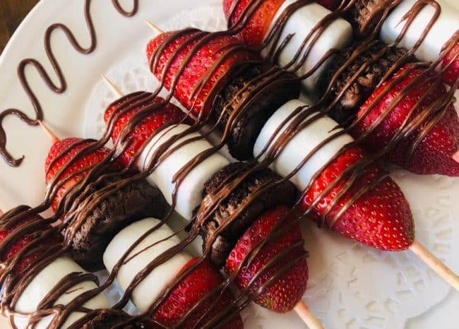 Assortment of strawberries, brownie and marshmallow dipped in chocolate on a skewer