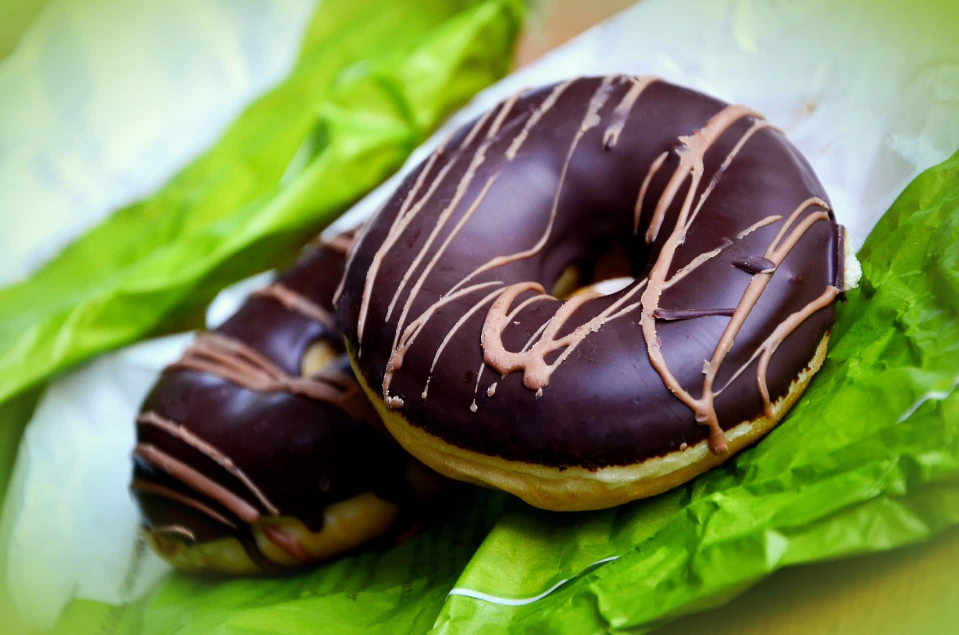 Donuts with chocolate icing on bright green napkins