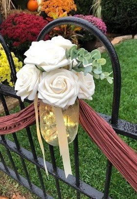 Black iron fence with lighted jar filled with roses