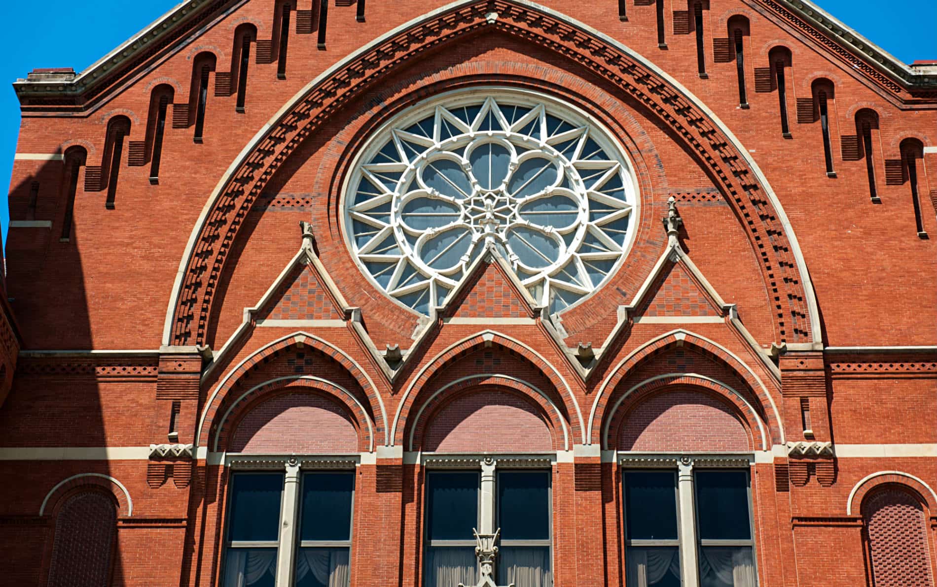 Historic red brick building with three arched windows