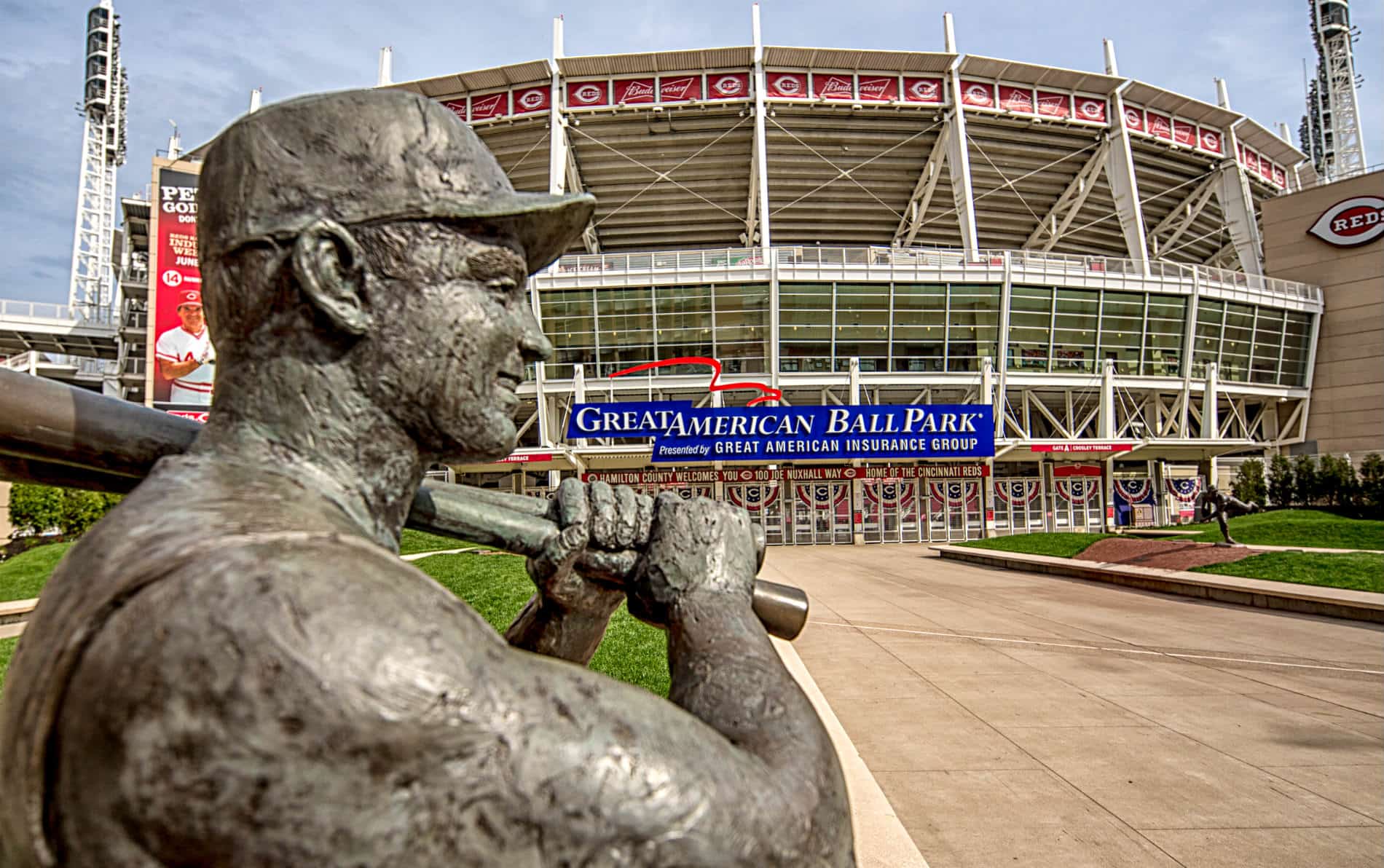 Large gray sculpture of baseball player in front of Great American Ballpark baseball stadium