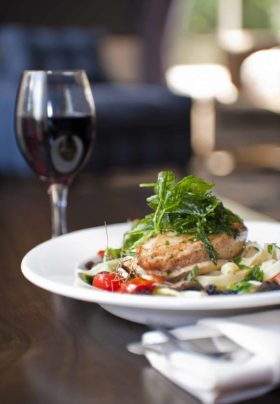 Gourmet chicken meal with glass of red wine