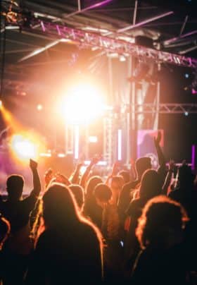 People dancing and enjoying music and lightshows at the concert