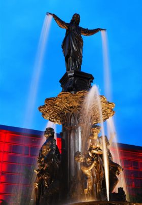 Man standing on top of a colorful fountain