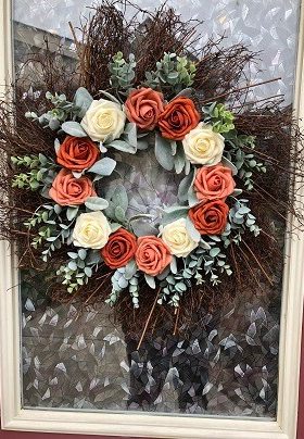 Wreath on a door with rust and coral roses